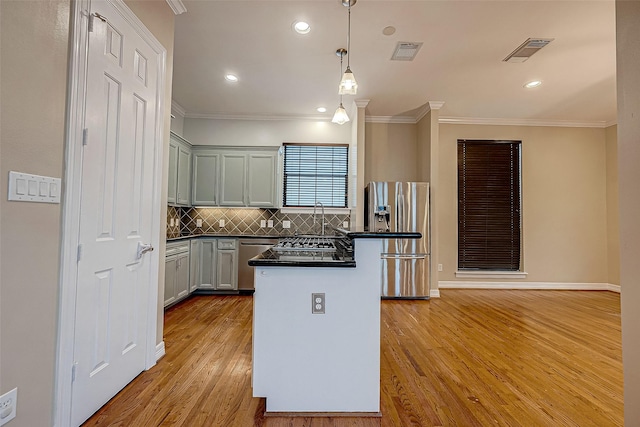 5331 Nolda St Unit A, Houston, TX 77007 - kitchen featuring appliances with stainless steel finishes, dark countertops, ornamental molding, light wood-type flooring, and tasteful backsplash