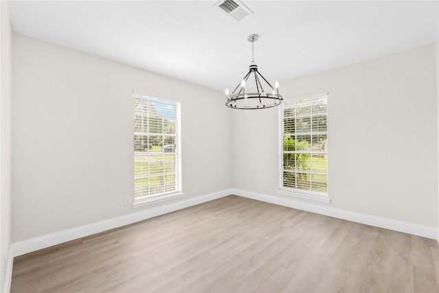 3101 Possum Trot St, Brenham, TX 77833 - empty room featuring a chandelier, light wood finished floors, and plenty of natural light