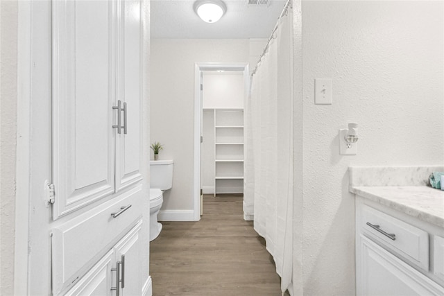 3101 Possum Trot St, Brenham, TX 77833 - full bath with wood finished floors, vanity, and a textured wall