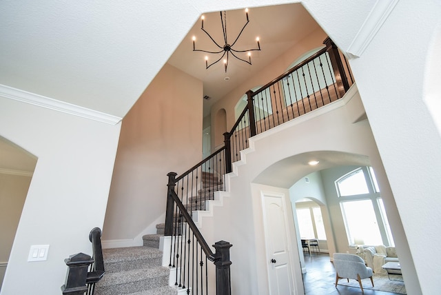 19019 Kimber Creek Ln, Cypress, TX 77429 - stairs with arched walkways, a towering ceiling, a chandelier, crown molding, and carpet