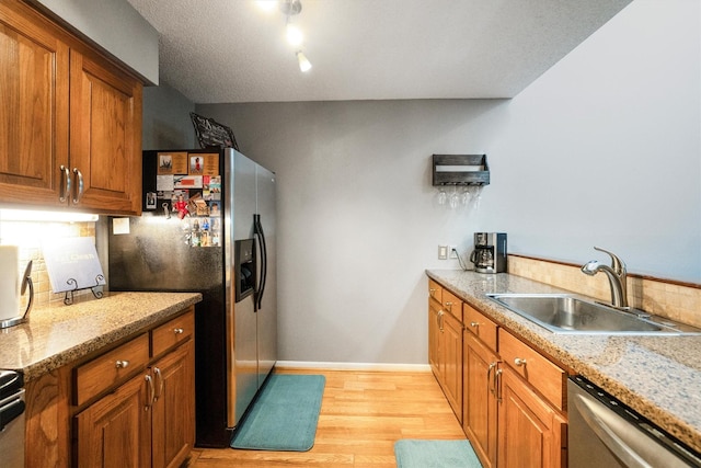 1501 Wimbledon Dr, Huntsville, TX 77340 - kitchen with brown cabinets, stainless steel appliances, and light wood finished floors