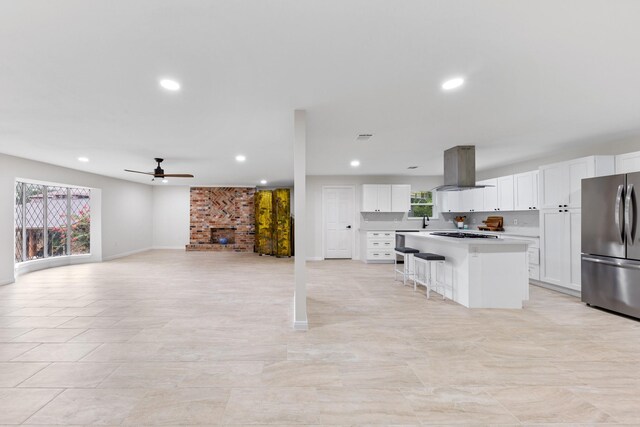 3915 Southmore Cir, Houston, TX 77004 - kitchen with freestanding refrigerator, island exhaust hood, a kitchen island, white cabinetry, and recessed lighting