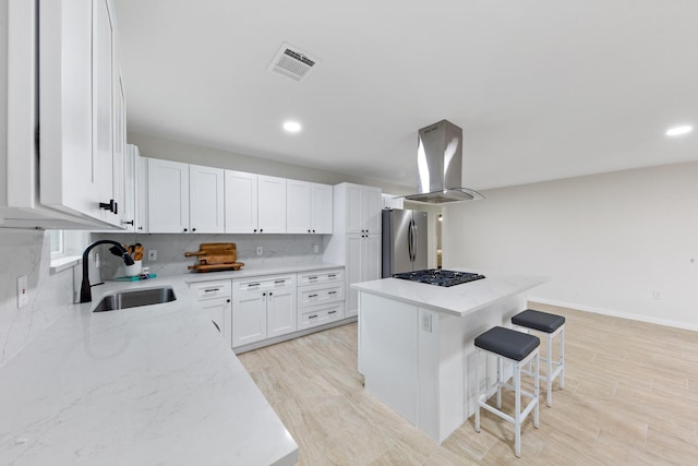 3915 Southmore Cir, Houston, TX 77004 - kitchen featuring freestanding refrigerator, island range hood, a center island, light stone counters, and light wood-type flooring