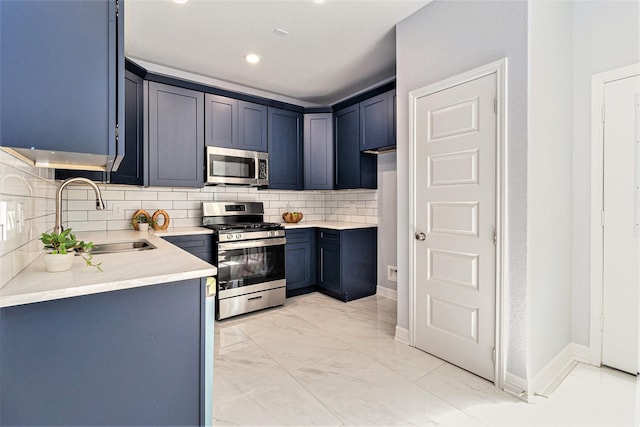 9311 Noel St, Houston, TX 77033 - kitchen with stainless steel appliances, decorative backsplash, light marble finish floors, recessed lighting, and blue cabinets