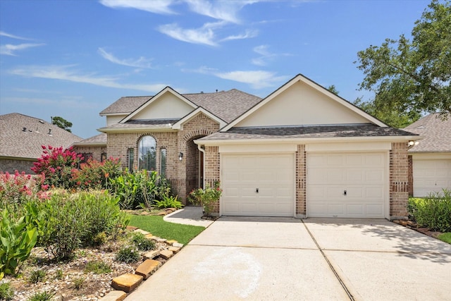 25207 Oak Star Dr, Spring, TX 77389 - view of front facade featuring concrete driveway, brick siding, a shingled roof, and a garage