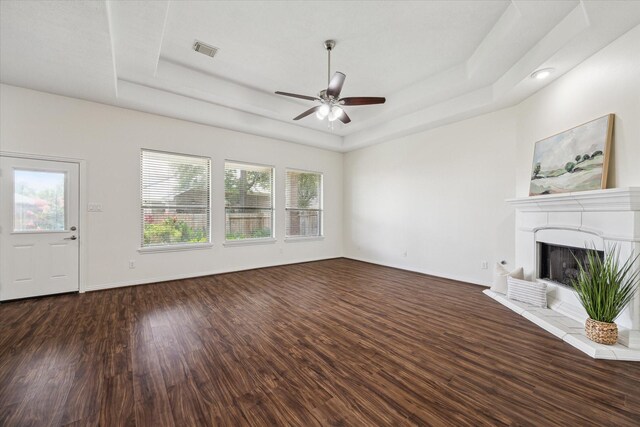 25207 Oak Star Dr, Spring, TX 77389 - unfurnished living room featuring a raised ceiling, a ceiling fan, dark wood-type flooring, and a fireplace with raised hearth