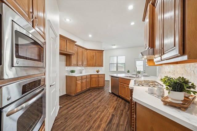 25207 Oak Star Dr, Spring, TX 77389 - kitchen with stainless steel appliances, brown cabinetry, light countertops, dark wood-style floors, and tasteful backsplash