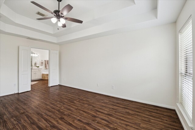 25207 Oak Star Dr, Spring, TX 77389 - unfurnished bedroom with a tray ceiling, dark wood finished floors, ensuite bathroom, and a ceiling fan