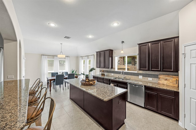 12314 Meadow Blossom Ln, Cypress, TX 77433 - kitchen featuring stainless steel dishwasher, dark brown cabinets, a kitchen island, light stone countertops, and hanging light fixtures