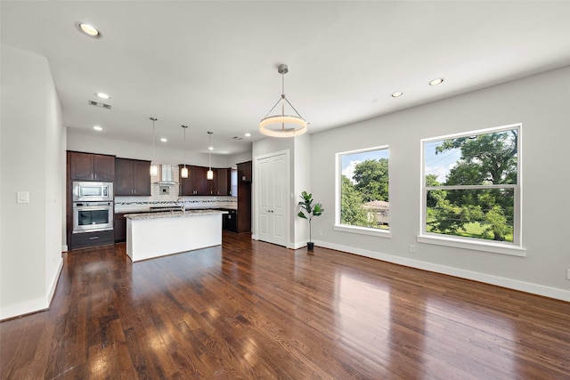 1005 Bingham St Unit 5, Houston, TX 77007 - kitchen with stainless steel appliances, wall chimney exhaust hood, backsplash, dark brown cabinets, and recessed lighting