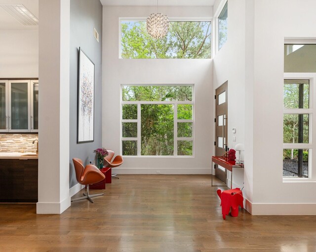 18 Pronghorn Pl, The Woodlands, TX 77389 - sitting room with a high ceiling, wood finished floors, and a chandelier