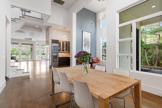 18 Pronghorn Pl, The Woodlands, TX 77389 - dining room featuring a towering ceiling, dark wood-style floors, beverage cooler, and recessed lighting