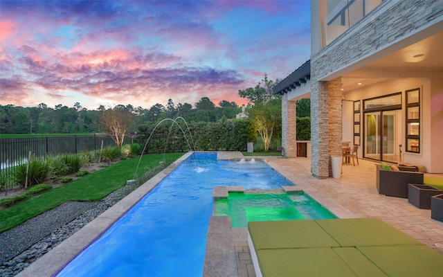 18 Pronghorn Pl, The Woodlands, TX 77389 - pool at dusk with a fenced backyard, a patio area, and a pool with connected hot tub