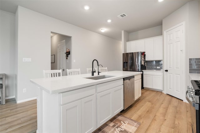 13402 Rain Lily, Texas City, TX 77568 - kitchen with appliances with stainless steel finishes, backsplash, light wood-type flooring, an island with sink, and recessed lighting