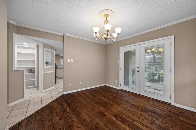 1406 Diana Ct, Houston, TX 77062 - unfurnished dining area featuring a chandelier, french doors, wood finished floors, a textured ceiling, and crown molding