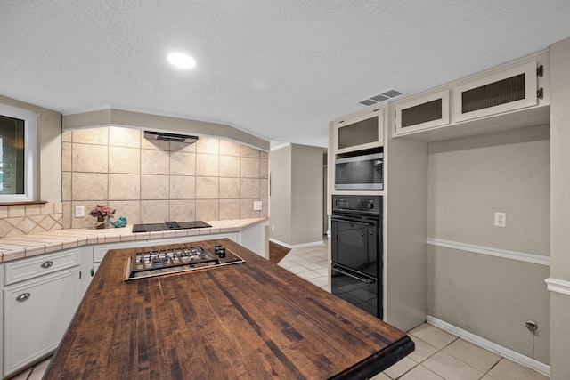 1406 Diana Ct, Houston, TX 77062 - kitchen with stainless steel appliances, light tile patterned flooring, wooden counters, decorative backsplash, and a textured ceiling