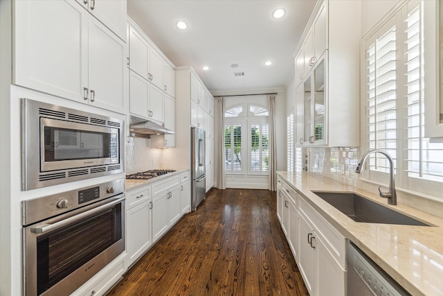 1206 Lake Pointe Pkwy, Sugar Land, TX 77478 - kitchen featuring appliances with stainless steel finishes, white cabinetry, dark wood-style floors, recessed lighting, and decorative backsplash