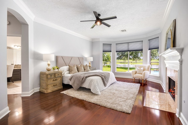 427 Crestwater Trl, Houston, TX 77082 - bedroom with arched walkways, dark wood finished floors, a high end fireplace, a textured ceiling, and crown molding