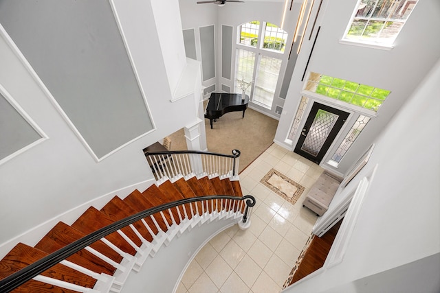 427 Crestwater Trl, Houston, TX 77082 - carpeted foyer featuring tile patterned flooring, stairs, healthy amount of natural light, a high ceiling, and ceiling fan