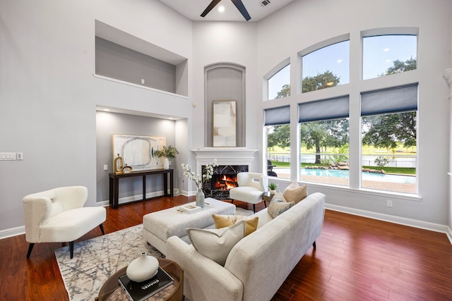 427 Crestwater Trl, Houston, TX 77082 - living area featuring a towering ceiling, a ceiling fan, a fireplace, and dark wood-style flooring