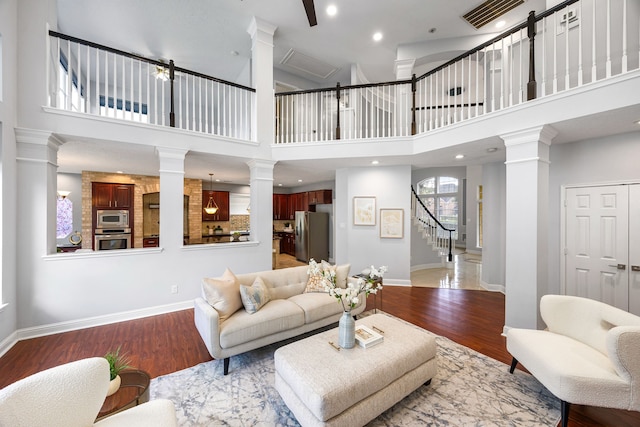 427 Crestwater Trl, Houston, TX 77082 - living room with ornate columns, wood finished floors, stairway, and a high ceiling