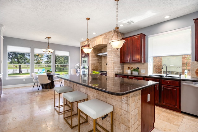 427 Crestwater Trl, Houston, TX 77082 - kitchen with stainless steel appliances, reddish brown cabinets, a kitchen island, decorative light fixtures, and decorative backsplash