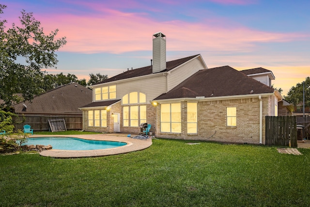 427 Crestwater Trl, Houston, TX 77082 - back of property at dusk featuring brick siding, a chimney, and a shingled roof