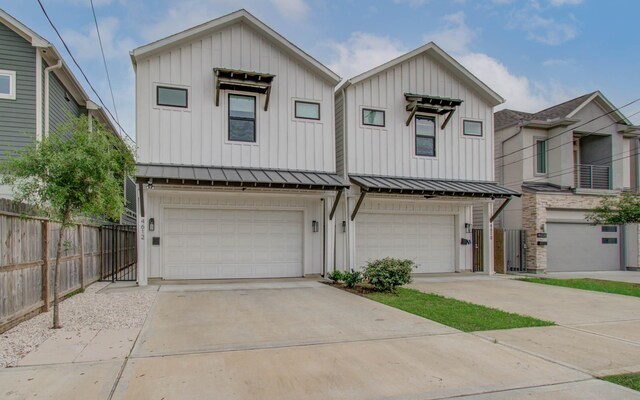 4612 Oats St, Houston, TX 77020 - view of front of house with board and batten siding, a garage, a standing seam roof, and concrete driveway