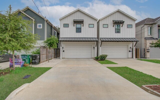 4612 Oats St, Houston, TX 77020 - view of front of house with board and batten siding, an attached garage, driveway, and a standing seam roof