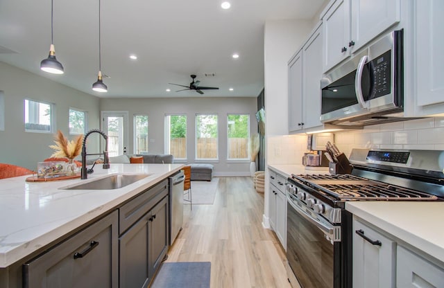 4612 Oats St, Houston, TX 77020 - kitchen featuring appliances with stainless steel finishes, plenty of natural light, light wood-style floors, recessed lighting, and decorative backsplash