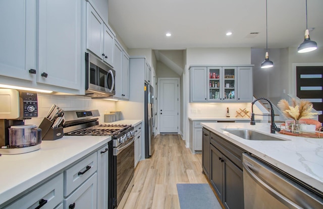 4612 Oats St, Houston, TX 77020 - kitchen with appliances with stainless steel finishes, tasteful backsplash, light wood-type flooring, glass insert cabinets, and recessed lighting