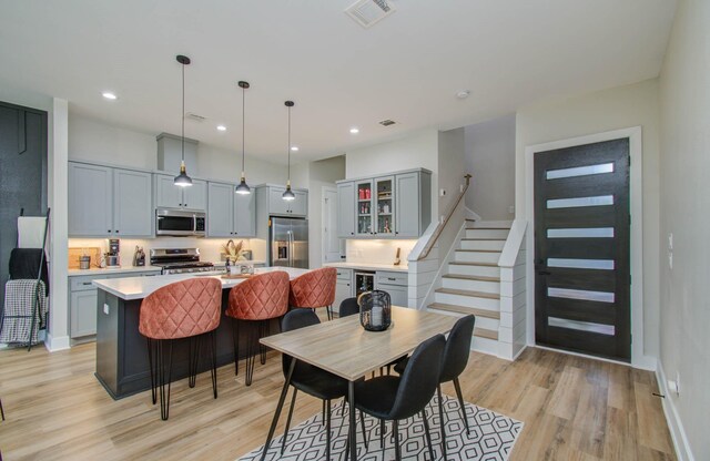 4612 Oats St, Houston, TX 77020 - dining area with light wood-type flooring, wine cooler, stairs, and recessed lighting