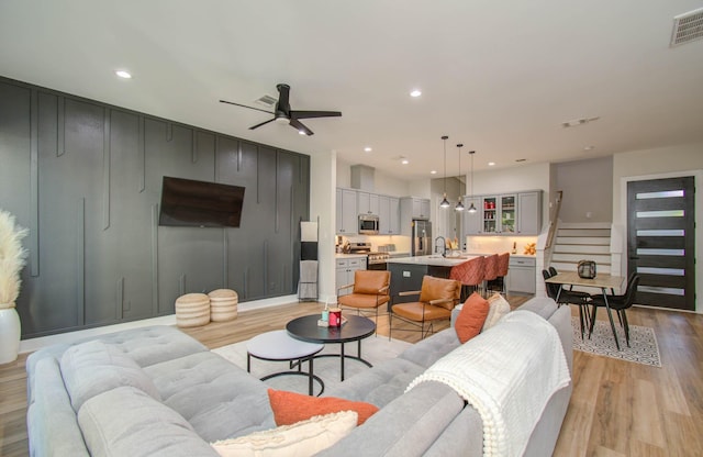 4612 Oats St, Houston, TX 77020 - living room featuring light wood-style floors, ceiling fan, stairs, and recessed lighting