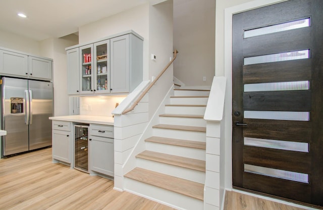 4612 Oats St, Houston, TX 77020 - stairs with beverage cooler, wood finished floors, a bar, and recessed lighting