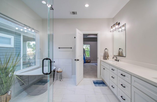 4612 Oats St, Houston, TX 77020 - bathroom with double vanity, a freestanding tub, marble finish floors, wainscoting, and recessed lighting