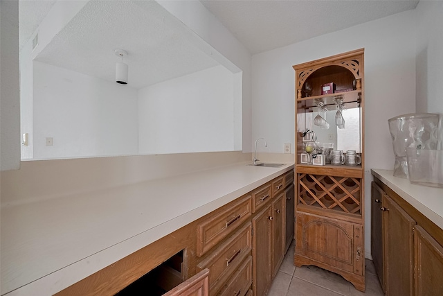 11280 Braes Forest Dr Unit 105, Houston, TX 77071 - kitchen with brown cabinetry, light countertops, and light tile patterned floors