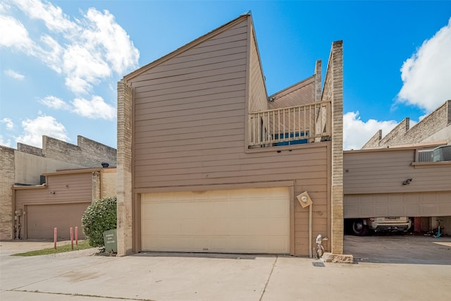 11280 Braes Forest Dr Unit 105, Houston, TX 77071 - view of side of home featuring a balcony, driveway, and an attached garage