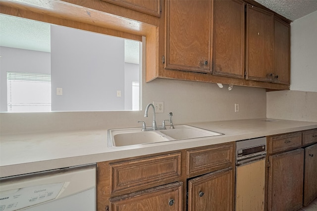 11280 Braes Forest Dr Unit 105, Houston, TX 77071 - kitchen featuring dishwasher, light countertops, a textured ceiling, and brown cabinets