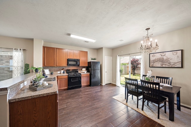 6707 Enchanted Crest Dr, Katy, TX 77449 - kitchen featuring black appliances, a chandelier, dark wood-type flooring, backsplash, and hanging light fixtures