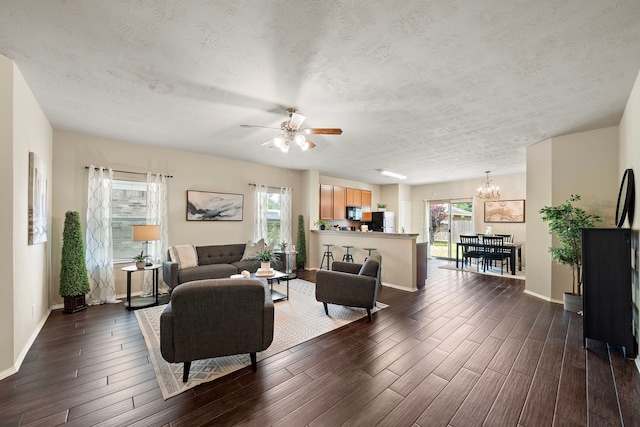 6707 Enchanted Crest Dr, Katy, TX 77449 - living area with dark wood-style flooring, a chandelier, ceiling fan, and a textured ceiling