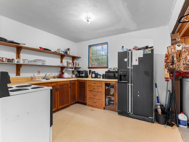 4432 County Road 886, Brazoria, TX 77422 - kitchen featuring black appliances, light flooring, brown cabinetry, light countertops, and a textured ceiling