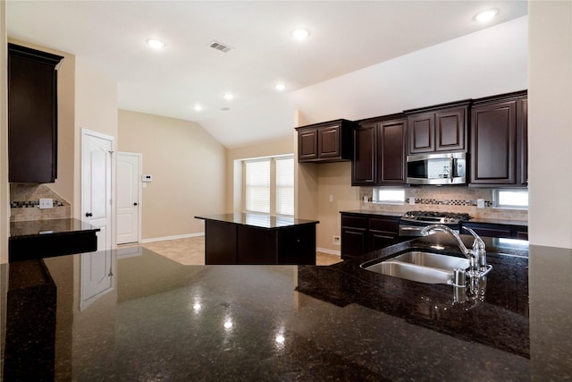 38 Tallgrass Way, Spring, TX 77389 - kitchen featuring stainless steel microwave, tasteful backsplash, vaulted ceiling, gas range oven, and dark brown cabinetry