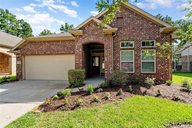 38 Tallgrass Way, Spring, TX 77389 - traditional-style home featuring brick siding, a garage, and driveway