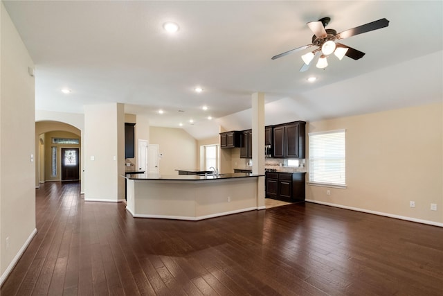 38 Tallgrass Way, Spring, TX 77389 - kitchen with dark countertops, a ceiling fan, arched walkways, dark wood-style flooring, and lofted ceiling