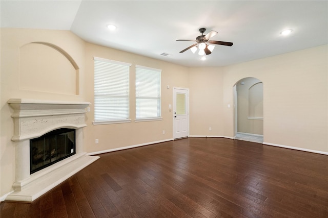 38 Tallgrass Way, Spring, TX 77389 - unfurnished living room featuring a ceiling fan, arched walkways, a glass covered fireplace, hardwood / wood-style floors, and recessed lighting