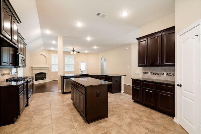 38 Tallgrass Way, Spring, TX 77389 - kitchen with stainless steel appliances, a center island with sink, ceiling fan, backsplash, and recessed lighting