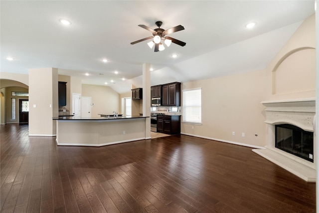 38 Tallgrass Way, Spring, TX 77389 - unfurnished living room with vaulted ceiling, arched walkways, a ceiling fan, plenty of natural light, and a glass covered fireplace