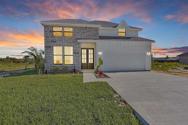 825 Rd 5501, Cleveland, TX 77327 - view of front of property featuring french doors, stone siding, roof with shingles, concrete driveway, and a lawn