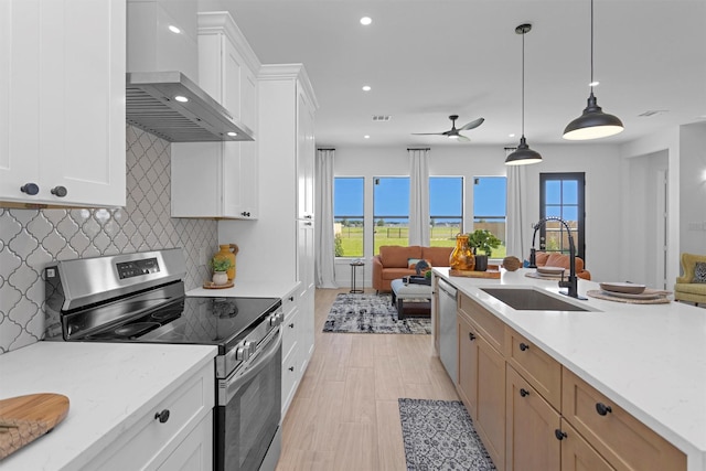 825 Rd 5501, Cleveland, TX 77327 - kitchen featuring appliances with stainless steel finishes, wall chimney exhaust hood, open floor plan, recessed lighting, and a ceiling fan