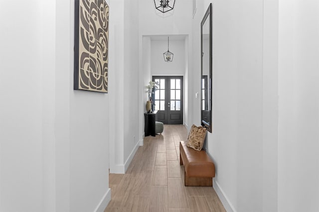 825 Rd 5501, Cleveland, TX 77327 - hallway with light wood-type flooring, a high ceiling, and a chandelier